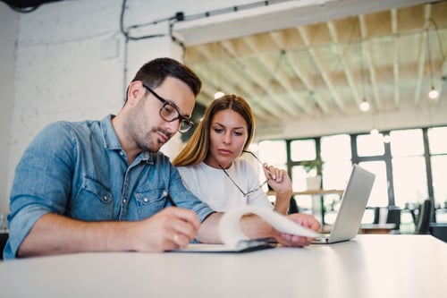 business couple at compute and taking notes