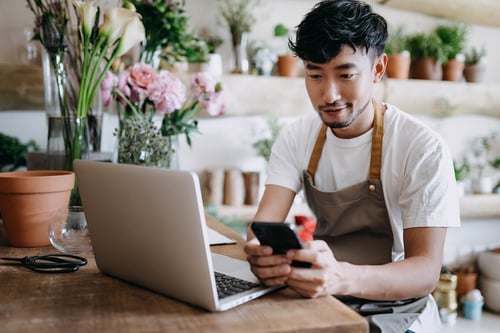 asian business ownere at computer