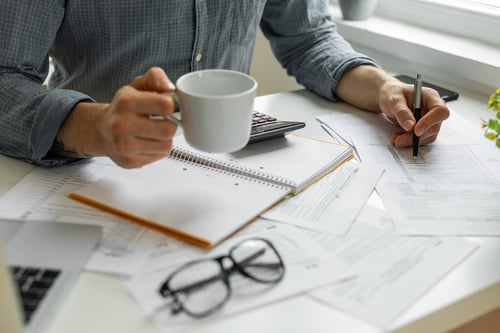  person looking at documents drinking coffee