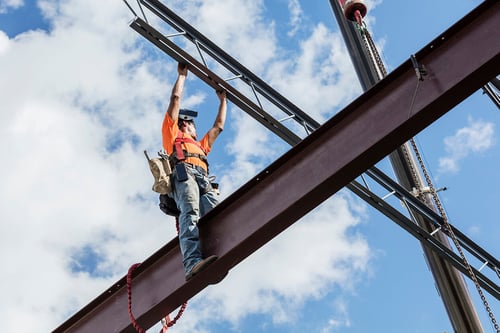 construction worker standing on a beam