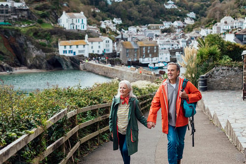 couple holding hands while traveling in retirement