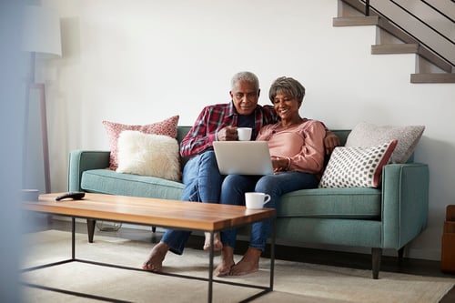 couple looking at a laptop at home on the couch