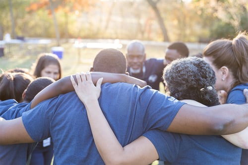 volunteer group hugging in a circle