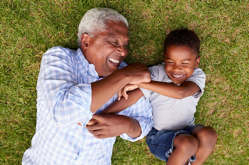 grandfather-laughing-with-grandson-in-the-grass