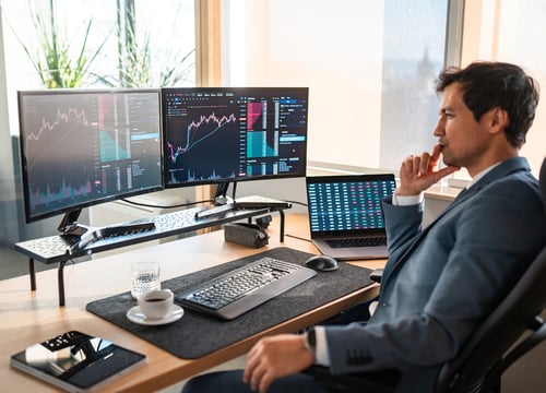working man sitting at a desk looking at charts analyzing