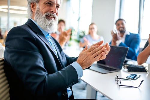 mature businessman clapping during a presentation