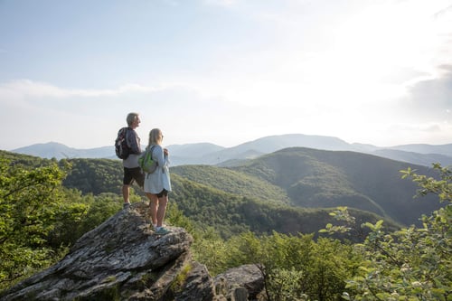 mature-couple-hiking-and-enjoying-the-view-from-a-mountain-in-retirement