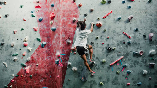 practicing rock climbing indoors at a training facility