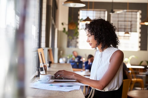 young professional working on a computer drinking coffee